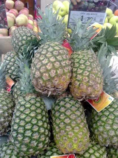 a pile of pineapples with price tags in them