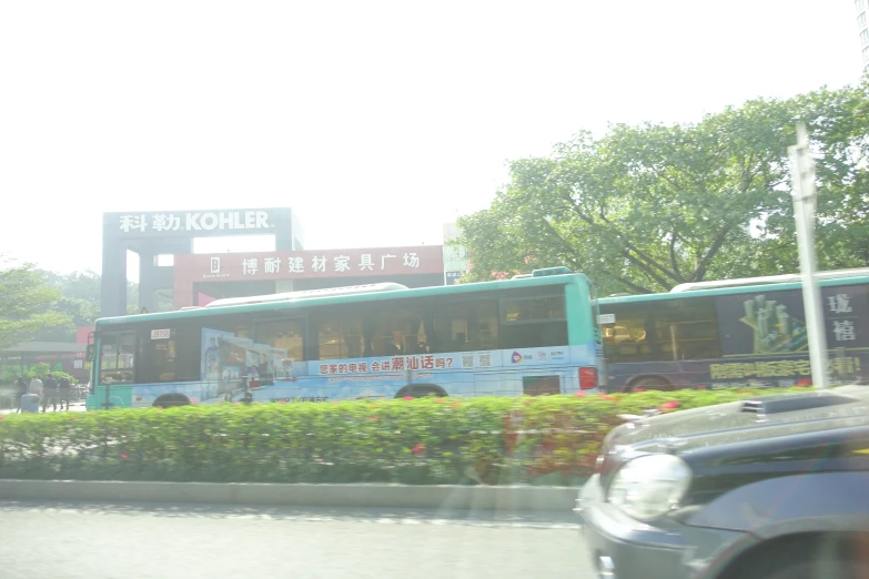 a green and blue bus driving down a road