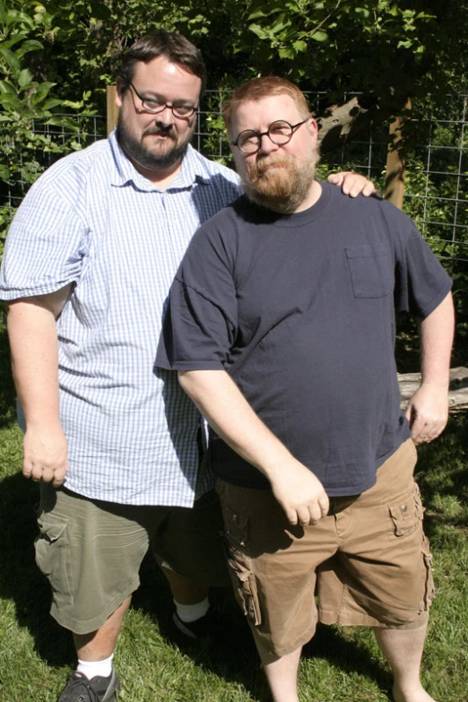 two men standing near one another while posing for the camera