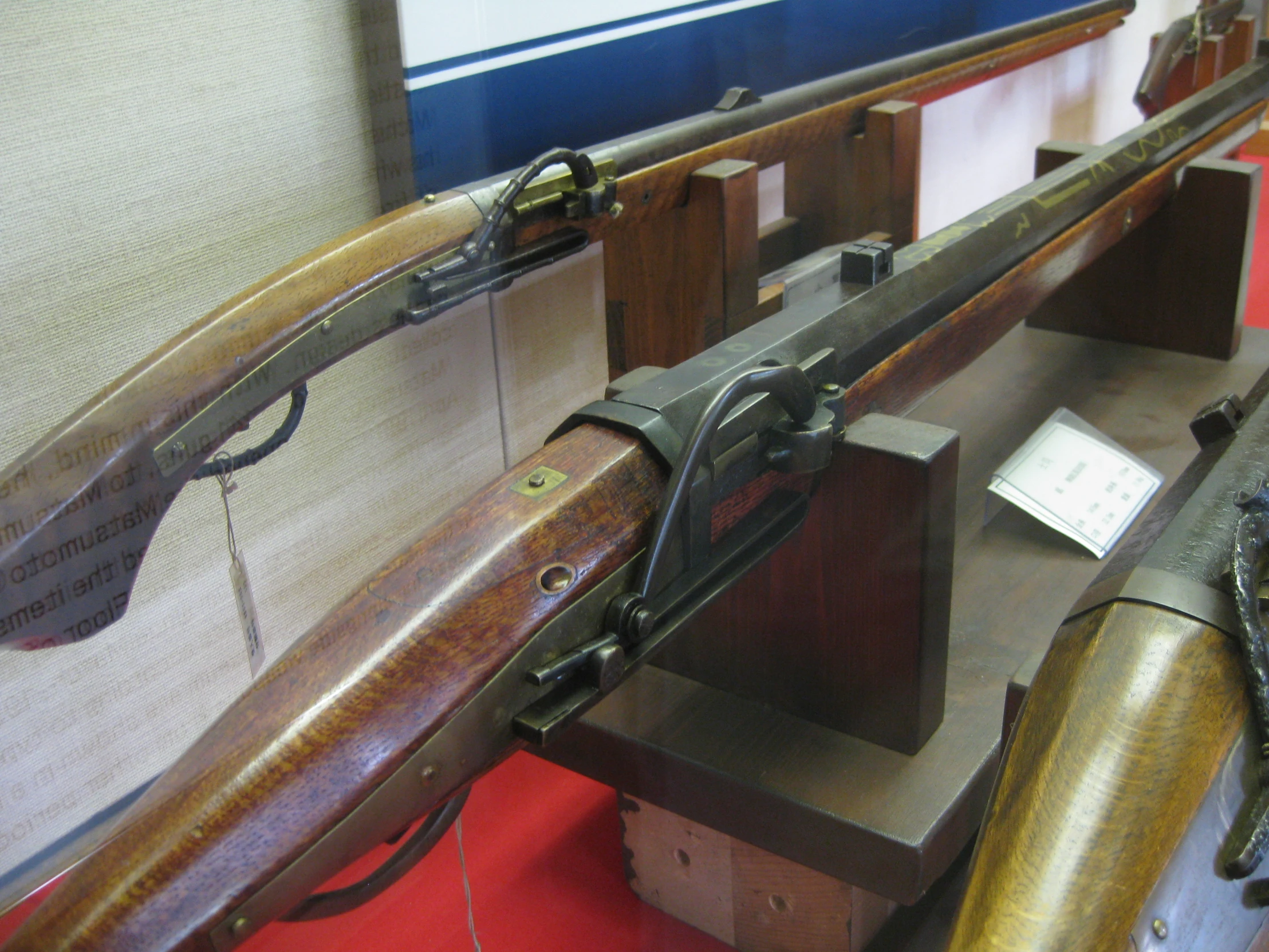 three different types of guns in wooden cases on display
