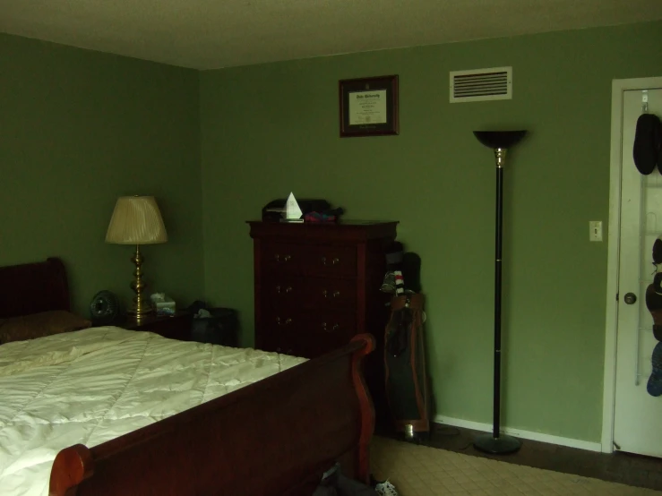 a bedroom with green walls, an open door and white bed