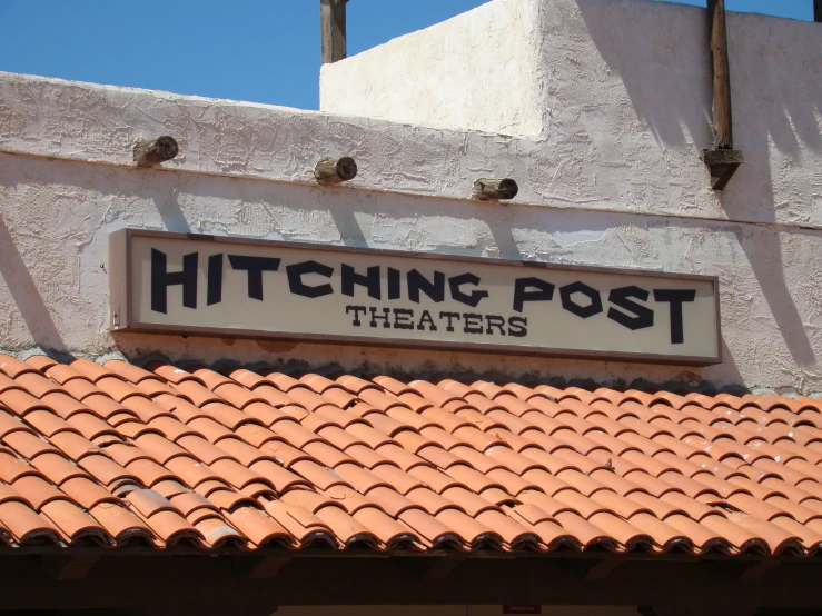 a sign on the side of a building reads hitching post theatre