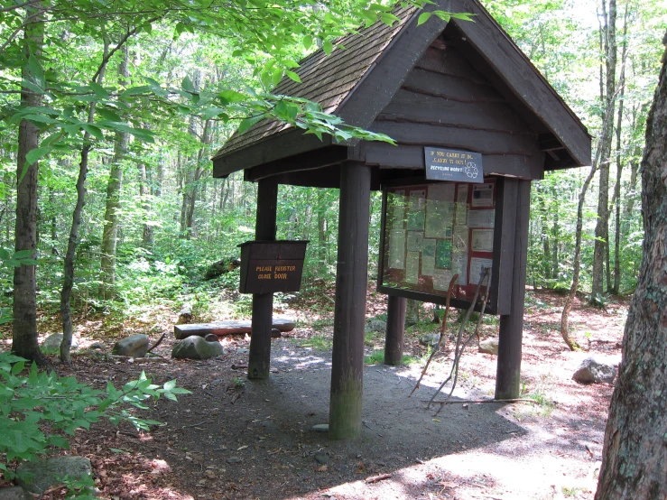 a wooden shelter sitting next to a forest