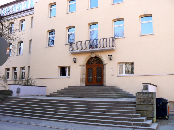 a large beige building with a stone wall