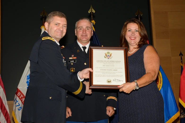 two men and a woman are posing in uniforms for a picture