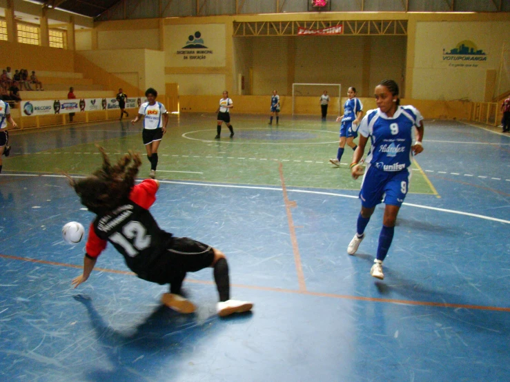 s playing soccer on a gymnasium floor