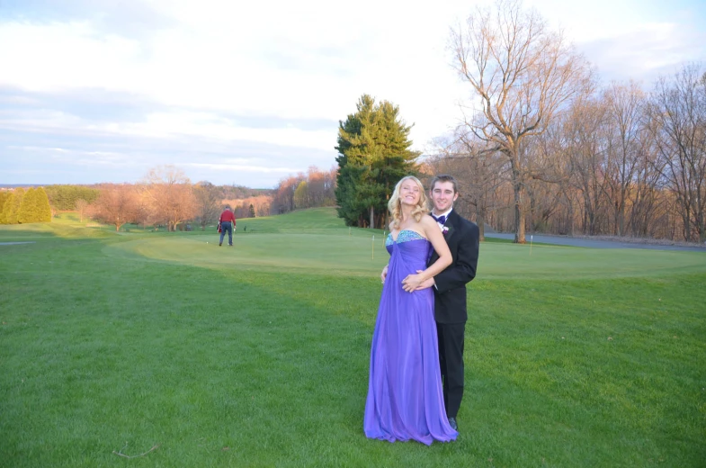 two people posing for a picture on a golf course