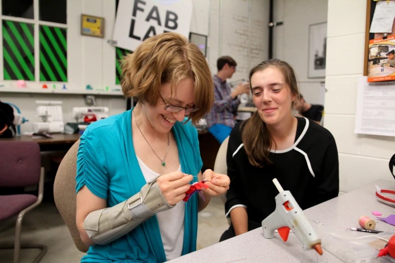 two women are looking at a project on the table