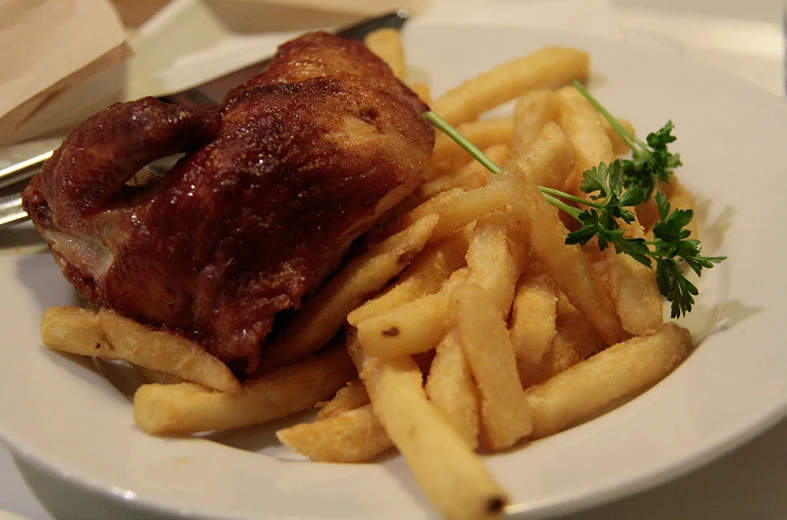 a plate with fries and a fork is sitting on the table