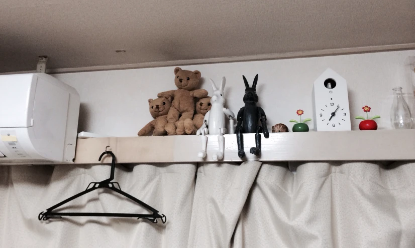 the wall in front of the bed has stuffed animals on it