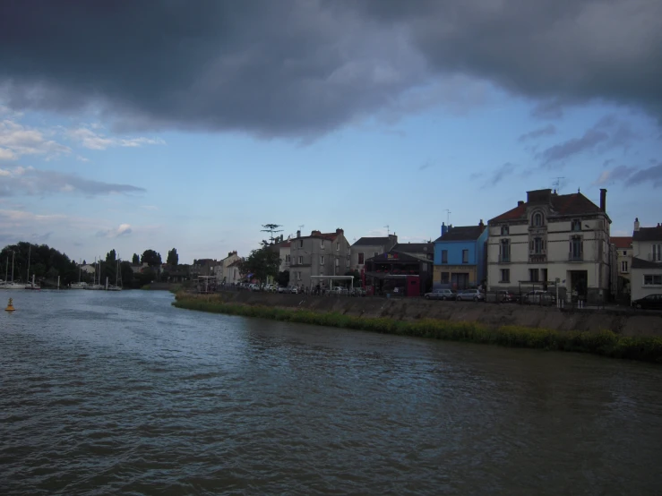 storm clouds loom above some homes and boats in a waterway