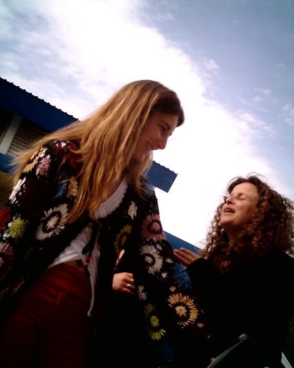 two women are standing next to each other smiling