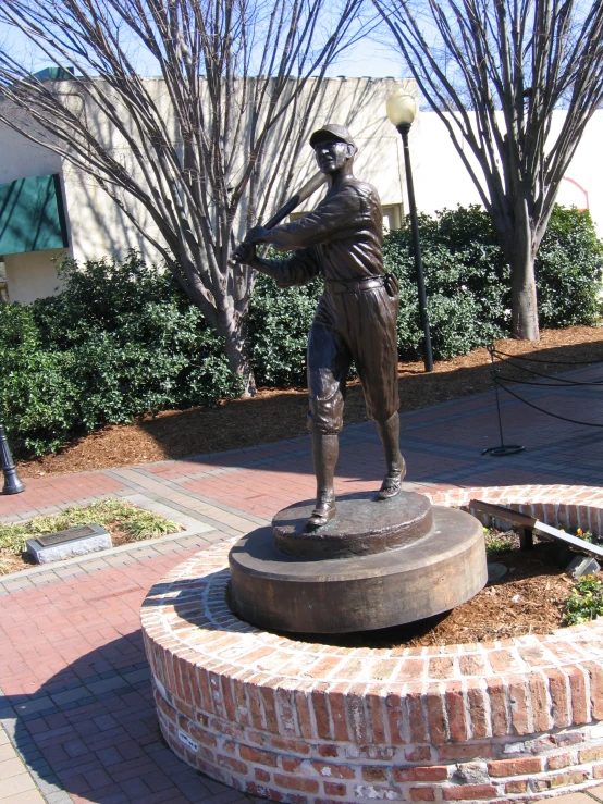 a statue is sitting on a brick wall