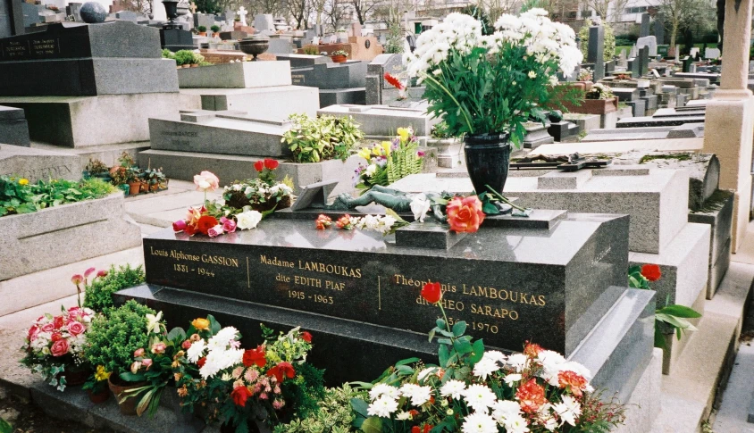 several flowered headstones and flowers in front of them