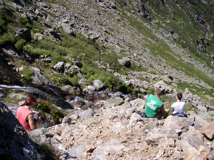 people sitting on the rocks and watching a hike