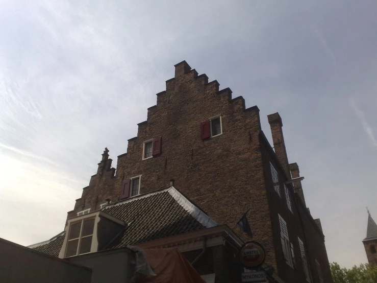 a brick structure has two stories and red shutters