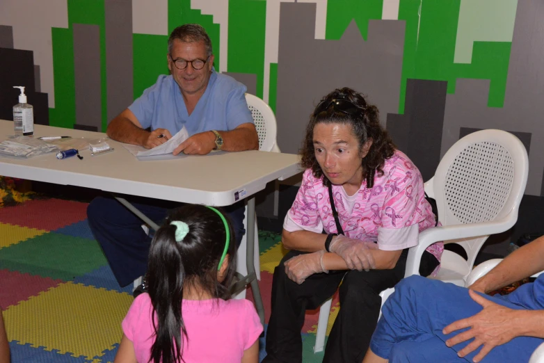 people in a classroom with an adult and  sitting at tables