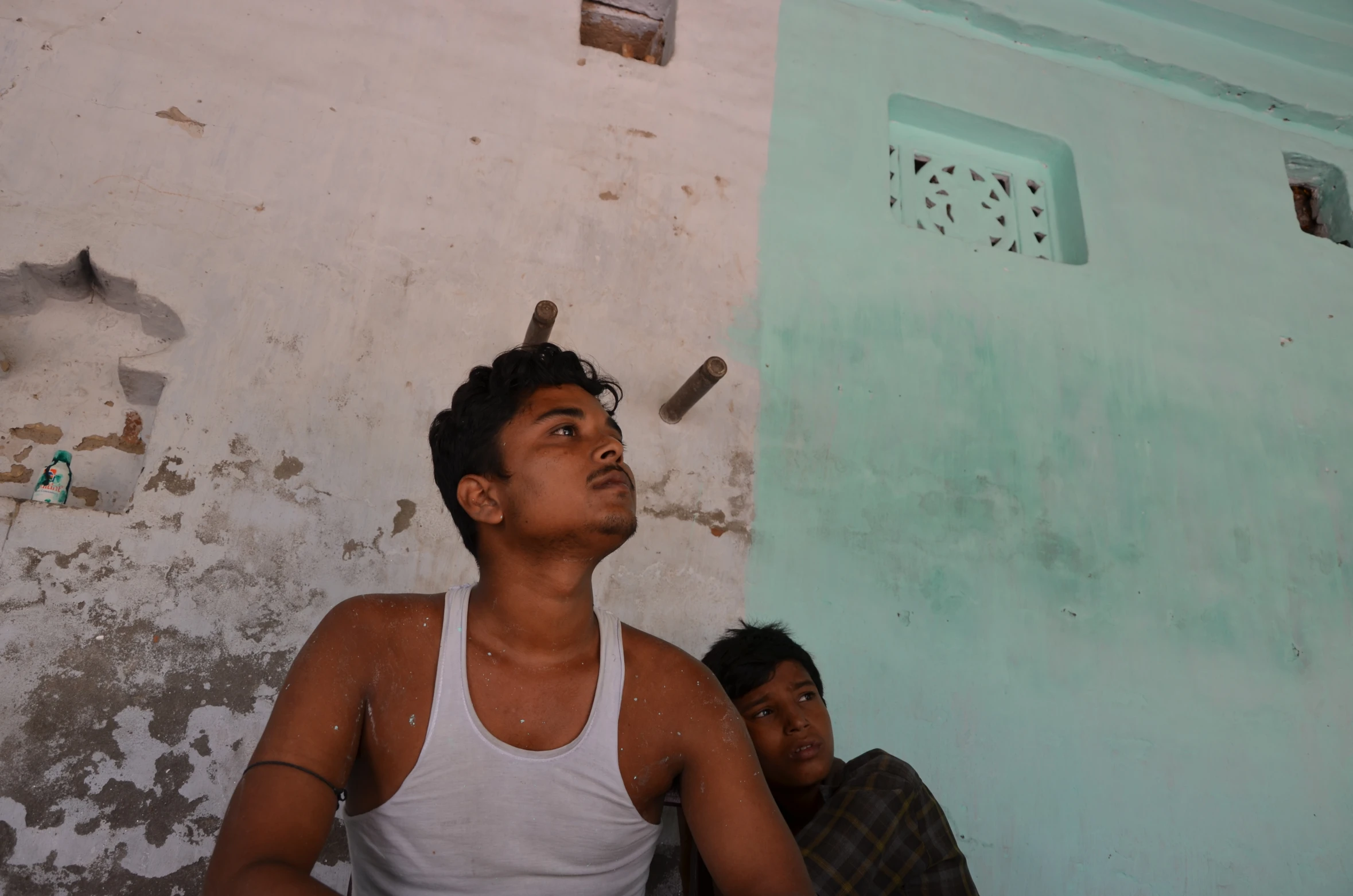 a man with his eyes closed in the corner of a house