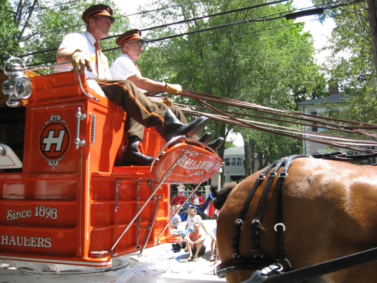 an orange horse and some people on a city street