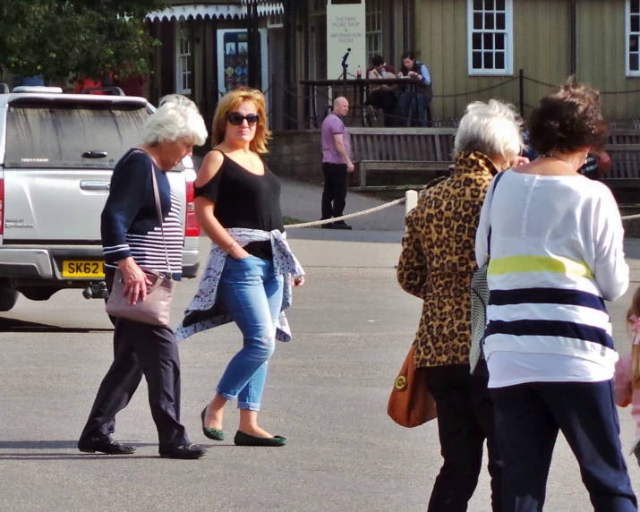 two women walking down the street with a dog