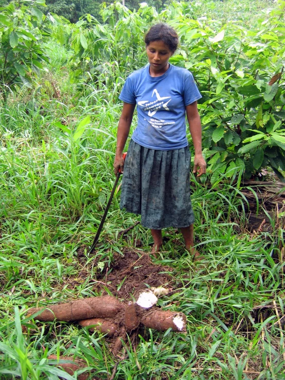 a woman holding a metal cane standing on a field