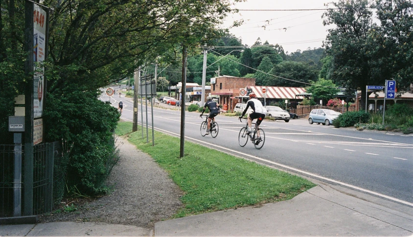 bicyclists ride down the road in the city