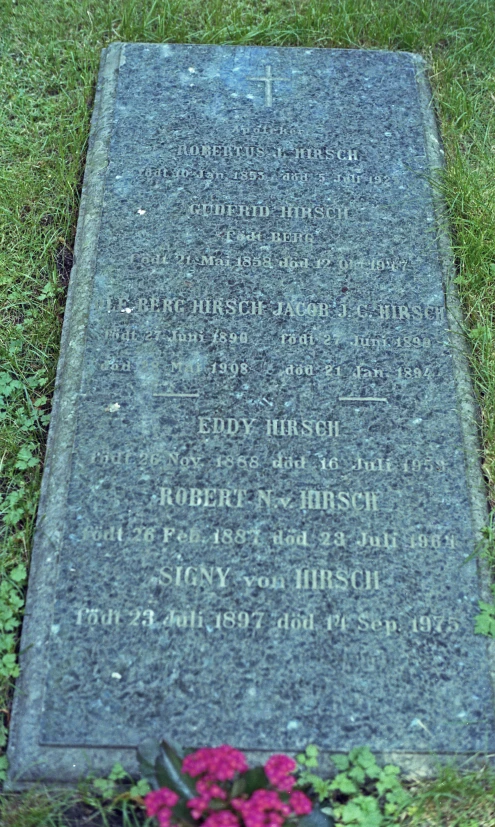 a memorial sits in a field with purple flowers and green grass