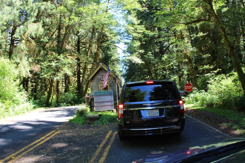 the back end of an suv driving along a rural road