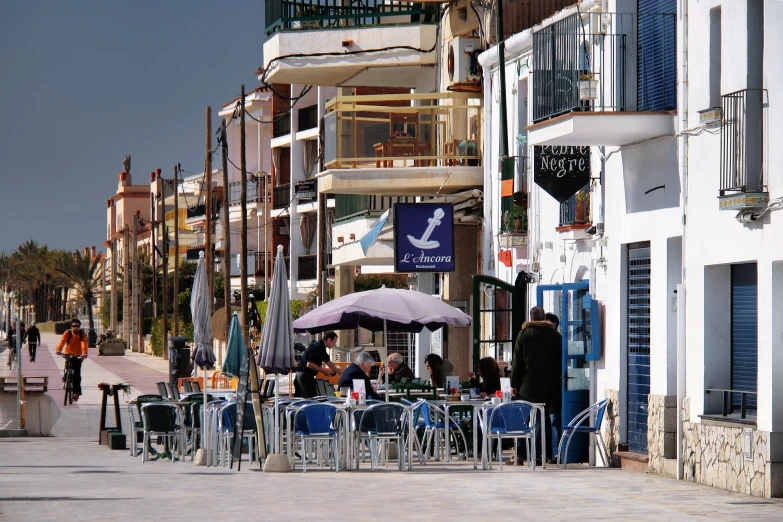 tables and chairs with umbrellas outside a el