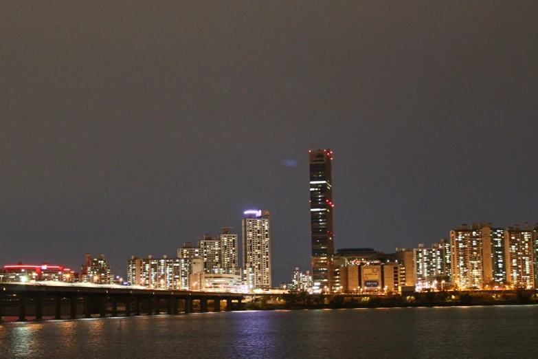 a city skyline with a bridge and illuminated buildings