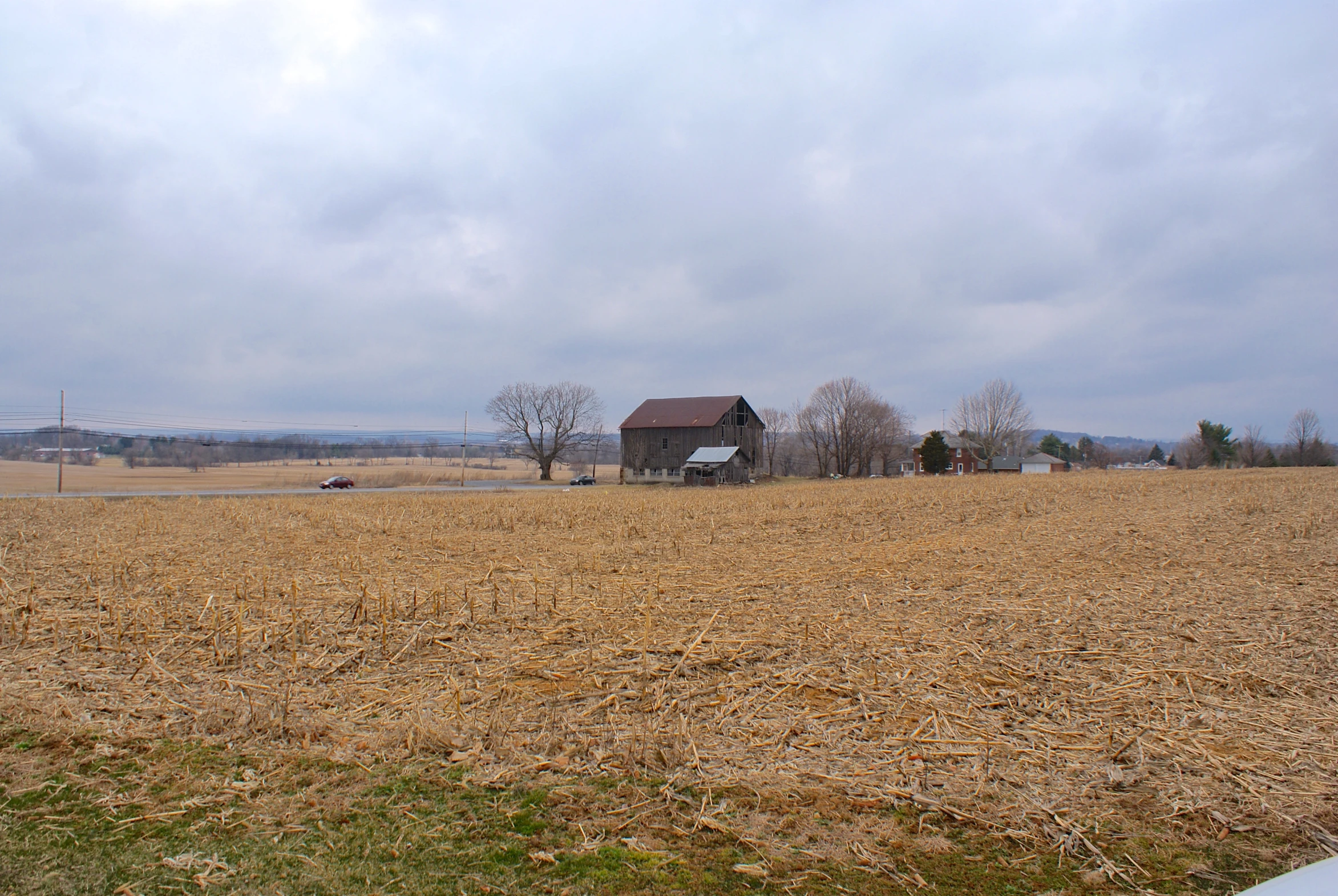 a barn sitting in the middle of a open field