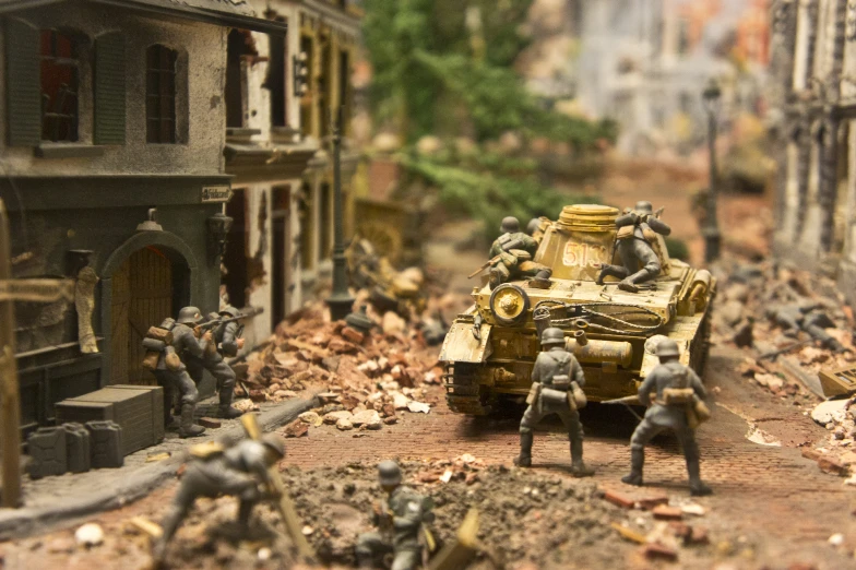 soldiers climbing up a hill in front of a toy army vehicle