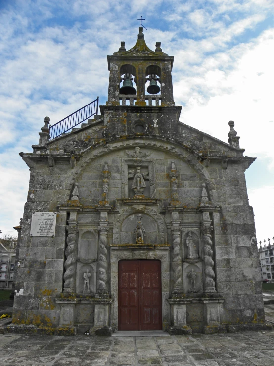 an old building with a tall tower has bells on top