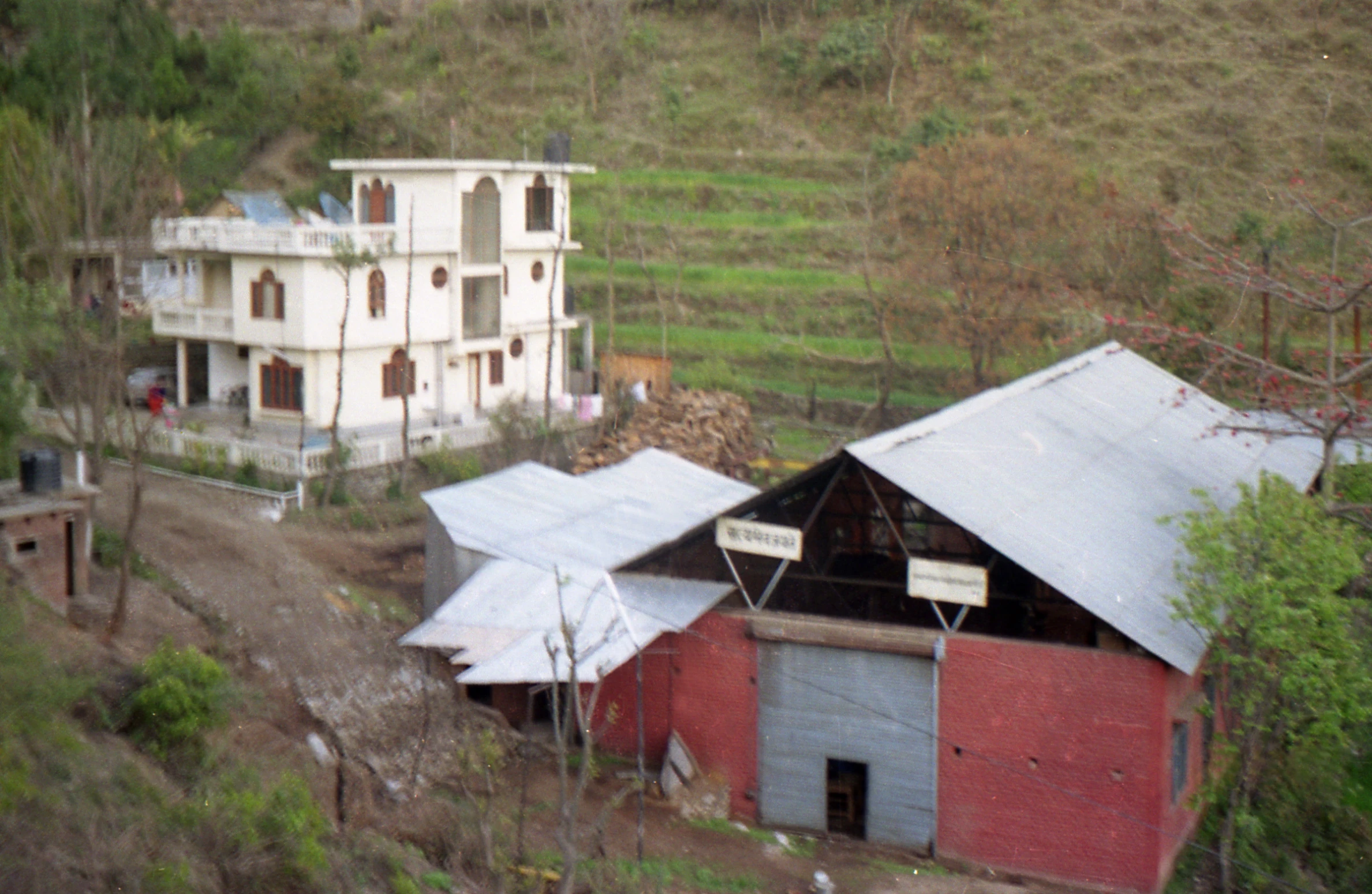 old buildings in a field near trees