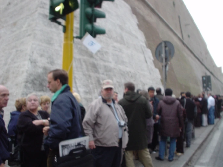 many people are standing around near a stop light