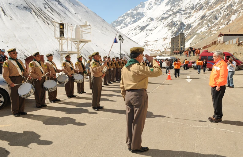 a band is performing in the mountains while men stand nearby