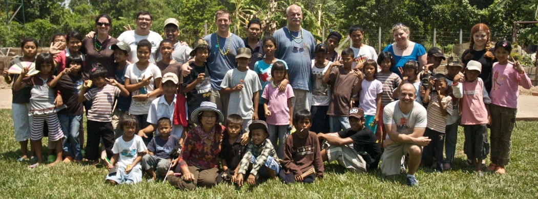 many children posing together for a group picture in the grass