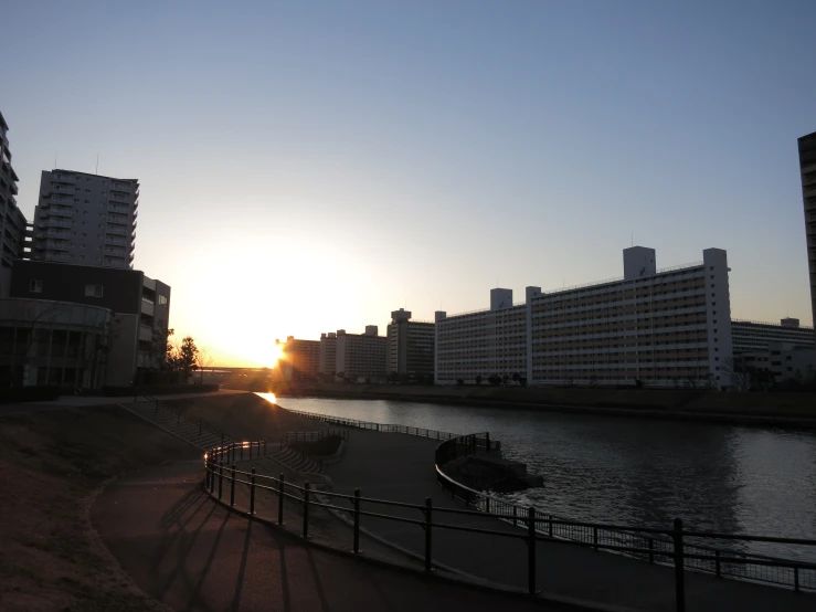 the sun sets behind buildings in an area