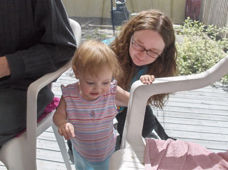 two s and an adult standing on the porch