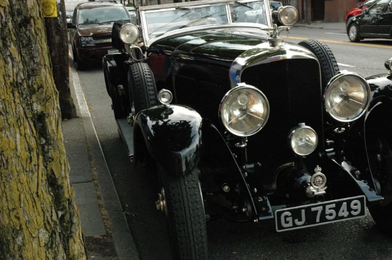 a vintage automobile parked on the street in a city