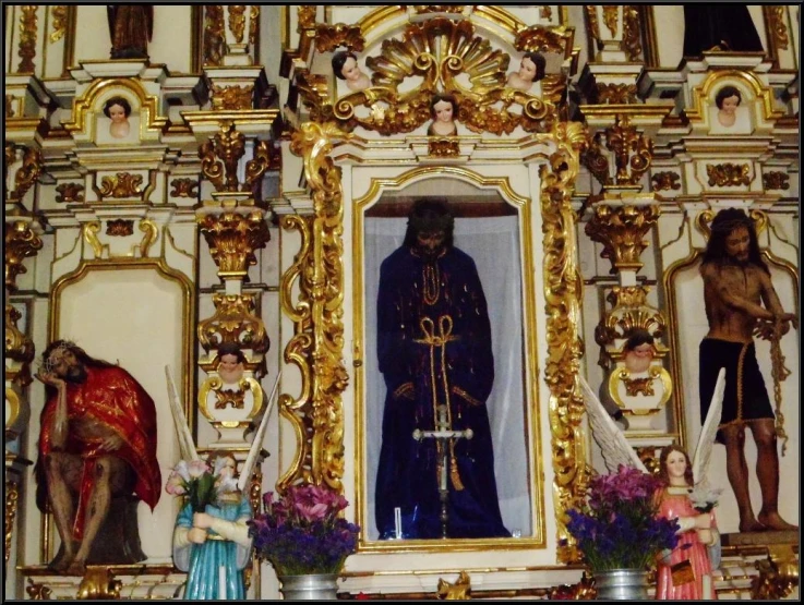 an elaborate gilded shrine with a gold leafwork on the wall