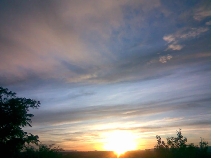 a sunset with a blue sky and lots of clouds