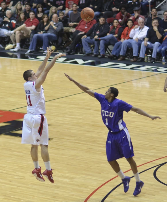 a young man jumping into the air to score a game of basketball