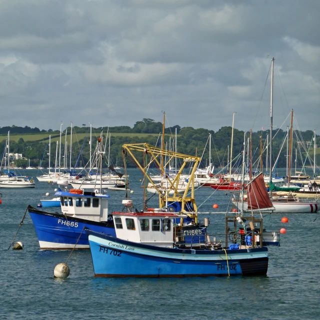 fishing boats are docked in the water with the sky above them