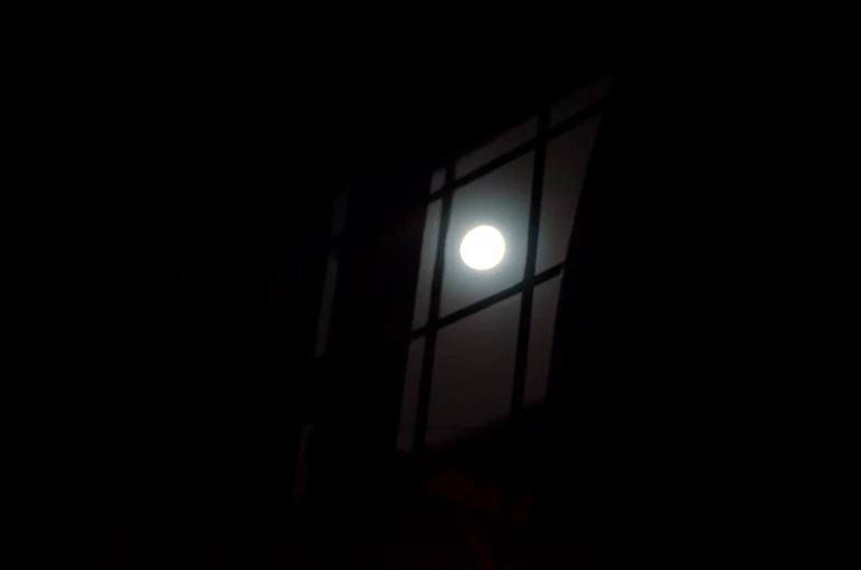 the moon through a window in a dark room