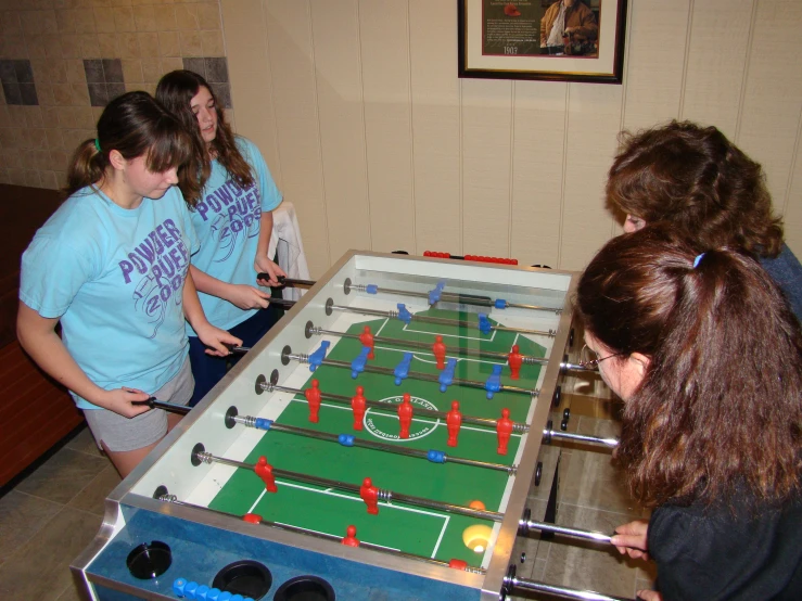 four girls playing soccer against each other in an office