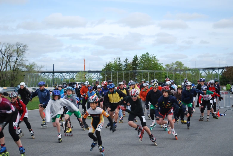 people in helmets and jerseys skating down a road