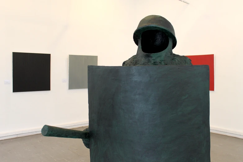 a sculpture sitting behind a large rectangular object