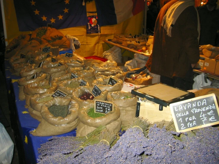 a market with bags of food on tables in the middle