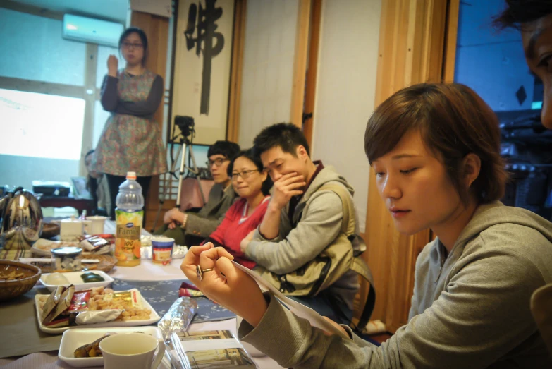 several people are sitting around a table with food on it